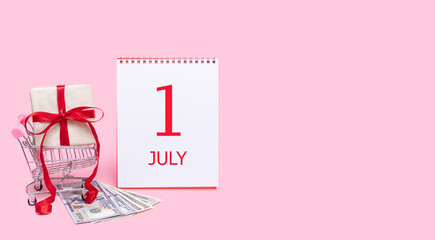A gift box in a shopping trolley, dollars and a calendar with the date of 1 july on a pink background.