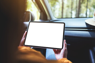 Mockup image of a woman holding and using digital tablet with blank screen in the car