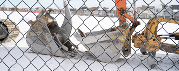 Construction equipment behind a wire mesh fence