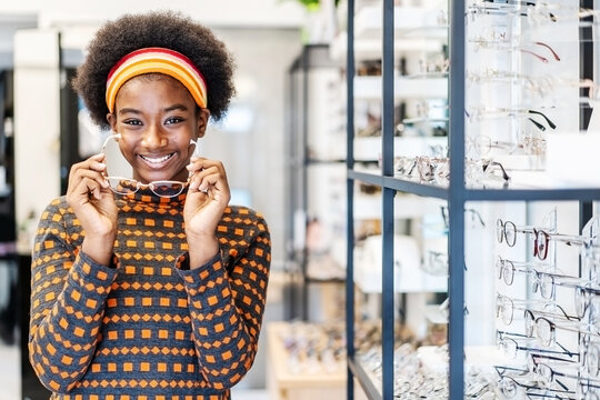 Need a new glasses. Young woman african american in optic store choosing a new eyeglasses frame. Medical, health care concept, used correct or assist defective eyesight