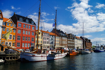 Scenic summer view of Nyhavn pier with old buildings, ships, yachts and other boats in the Old Town of Copenhagen, Denmark