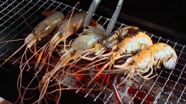 Grilled river shrimp on charcoal stove. Flame grilled prawn. 4K