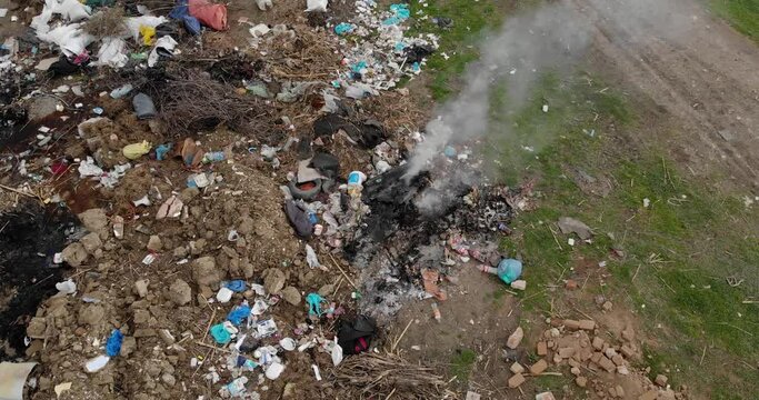 Pile of trash on the side of the road burning , close up