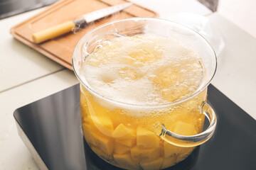 Cooking pot with boiling potatoes on electric stove