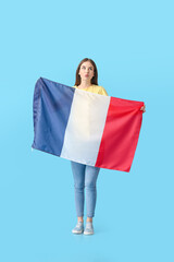 Beautiful young woman with the flag of France on color background