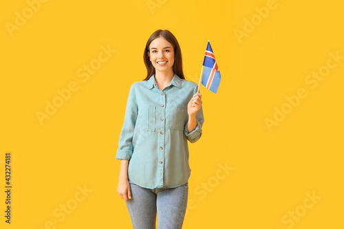 Beautiful young woman with the flag of Iceland on color background