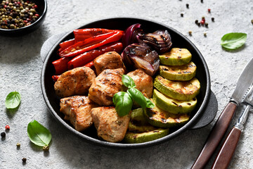 BBQ chicken fillet with grilled vegetables: onions, peppers, zucchini in a pan. Picnic.
