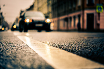 Rainy day in the big city, the car rides ahead on the road. Close up view from the level of the dividing line
