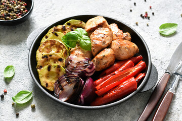 BBQ chicken fillet with grilled vegetables: onions, peppers, zucchini in a pan. Picnic.