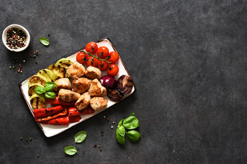 Grilled meat and vegetables set: tomatoes, onions, zucchini, peppers in a plate on a concrete background. Picnic. BBQ menu.