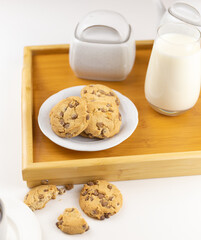 glass of milk and cookies on wooden tray