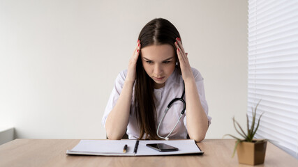 Sad, stressed, upset and unhappy face of a female doctor in a hospital. Depression, overwork, stress and pressure from overwork. A desperate doctor, medic, or nurse made a mistake.