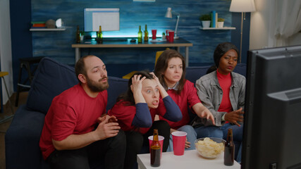 Group of multiethnic people frustrated after football team losing match competition during sport...