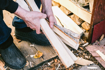 Village. Chop wood with an axe.Firewood for the stove. Firewood in the hands of a man.