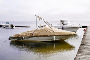 Boat covered with beige tarpaulin in harbor lacanau lake port france