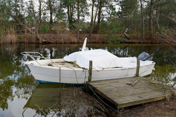 winter fibre glass cruise boat with white tarpaulin cover steering wheel and outboard dashboard...