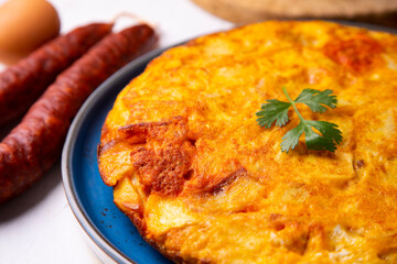 Traditional Spanish omelette cooked with chorizo, potatoes and onion. Traditional tapas of Spanish gastronomy.