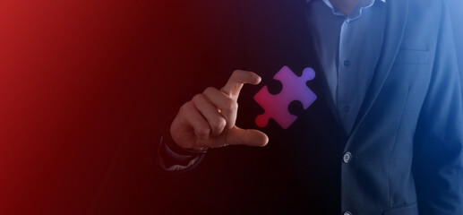 Businessman hands connecting puzzle pieces representing the merging of two companies or joint venture, partnership, Mergers and acquisition concept