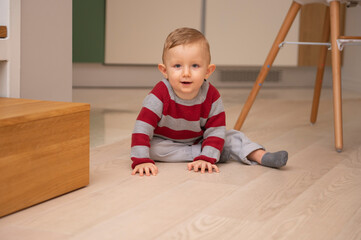 Cute little baby boy lying on hardwood