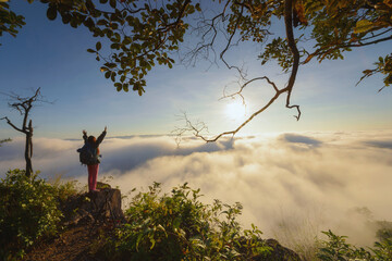 female hiker on top hills with arms out durin sunrise,cheering woman hiker open arms at mountain peak