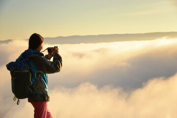 female hiker on top hills with arms out durin sunrise,cheering woman hiker open arms at mountain peak