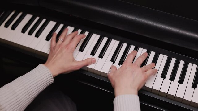 Professional pianist. The pianist performs playing a grand piano. Close-up of pianist's hands professionally play the piano.