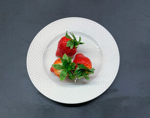 THREE large strawberries on a white porcelain plate