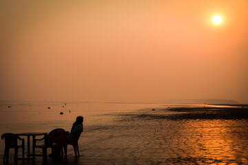 Man sitting sunset at the beach