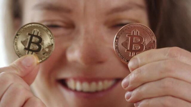 woman with bitkoin coins in front of her eyes