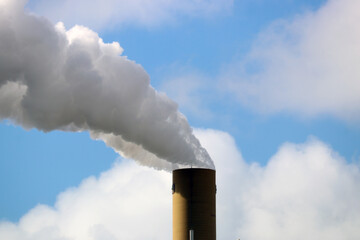 Steam comes out of a chimney at chemical factory in Rotterdam Harbor
