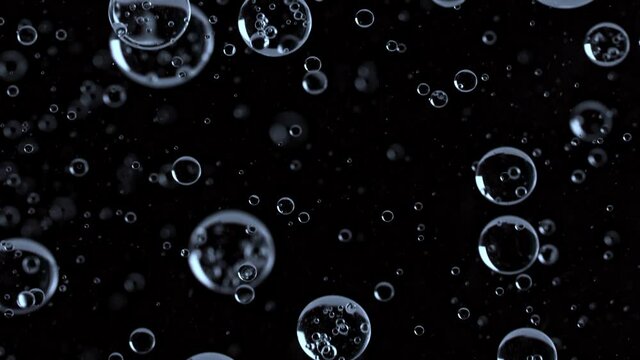 Super Slow Motion Macro Shot of Rising Various Bubbles on Black Background at 1000 fps.