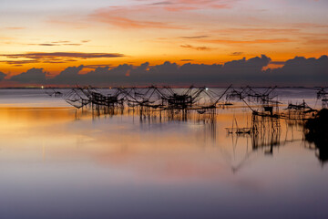 Obraz premium Beautiful landscape morning sky sunrise, Fishing using giant nets Thale Noi Wetlands at Baan Pak Pra is a famous landmark of Phatthalung, Thailand