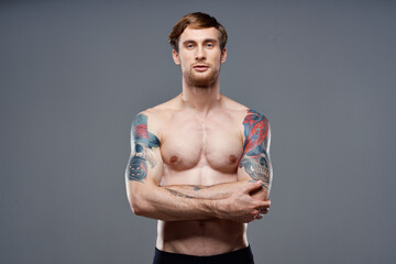 sport man cropped view workout tattoo on arms gray background