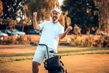 Fototapeta premium Portrait of senior golfer standing on court.