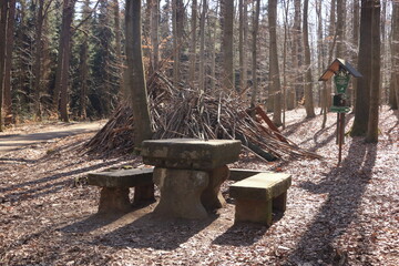 Rock table and chair in the forest background. Large nature stone table and bench in the park