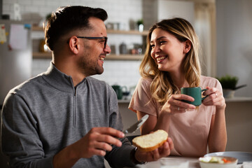 Husband and wife enjoying in breakfast. Loving couple drinking coffee in the kitchen.