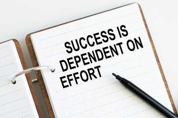 Business concept. Notebook with text SUCCESS IS DEPENDENT ON EFFORT