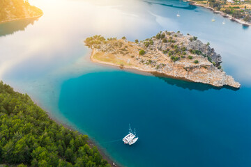 Yacht sailing near the rocky coast in Turkey. Luxury vacation at sea