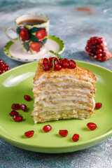 Delicious homemade crepe cake decorated with pomegranate seeds and mandarins.