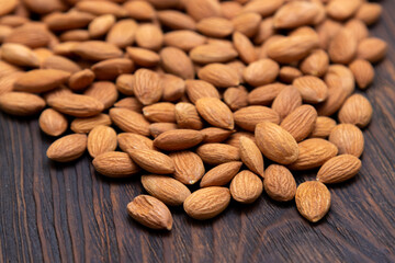 Dry nuts from an apricot kernel on a wooden table.