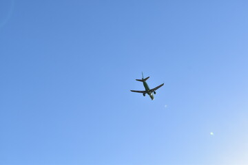 A plane flying in a clear blue sky.