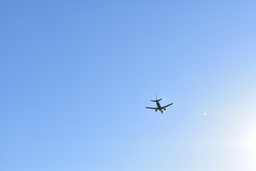 A plane is flying in a clear blue sky.