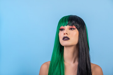 Beauty portrait of modern woman wearing long half green black wig. Bright male up