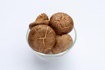 Fresh shiitake mushrooms in glass bowl on white