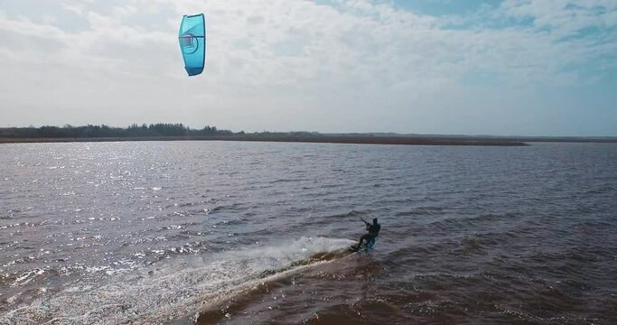 kitesurfer kiting on fjord aerial following drone 4k