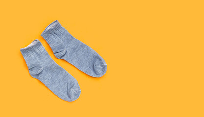 Grey socks on yellow background.