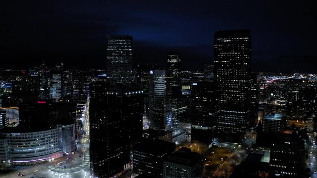 Aerial Shot Of Illuminated Buildings And Modern Skyscrapers Against Sky In City At Night, Drone Flying Forward - Denver, Colorado