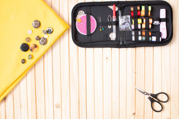 Sewing and objects for sewing on wooden background.