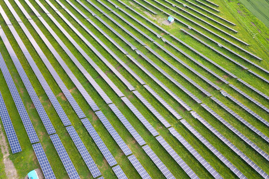 Aerial view of solar power plant on green field. Electric panels for producing clean ecologic energy.
