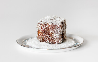 A simple Hungarian dessert called coconut cube. Sponge cake dipped in chocolate and rolled in coconut flakes.